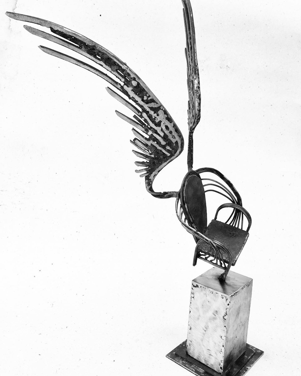 Escultura de Pedro Cuellar: alas de metal sobre un pedestal