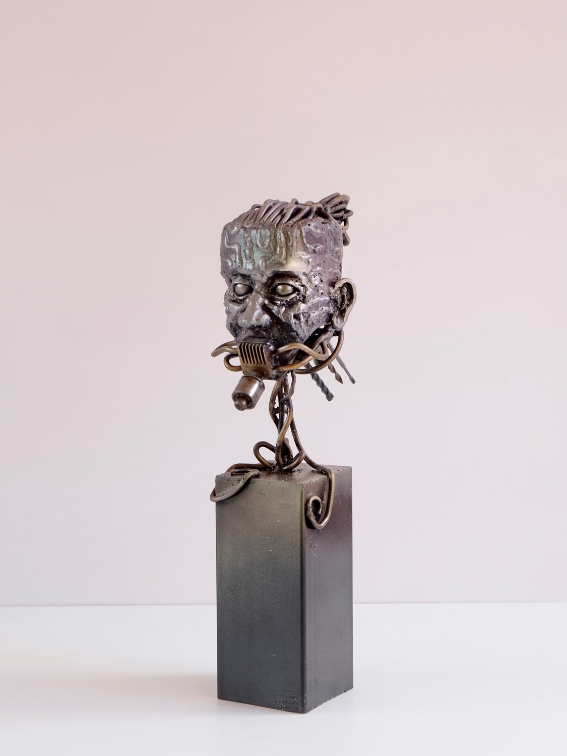 Escultura de Pedro Cuellar: busto de metal sobre un pedestal