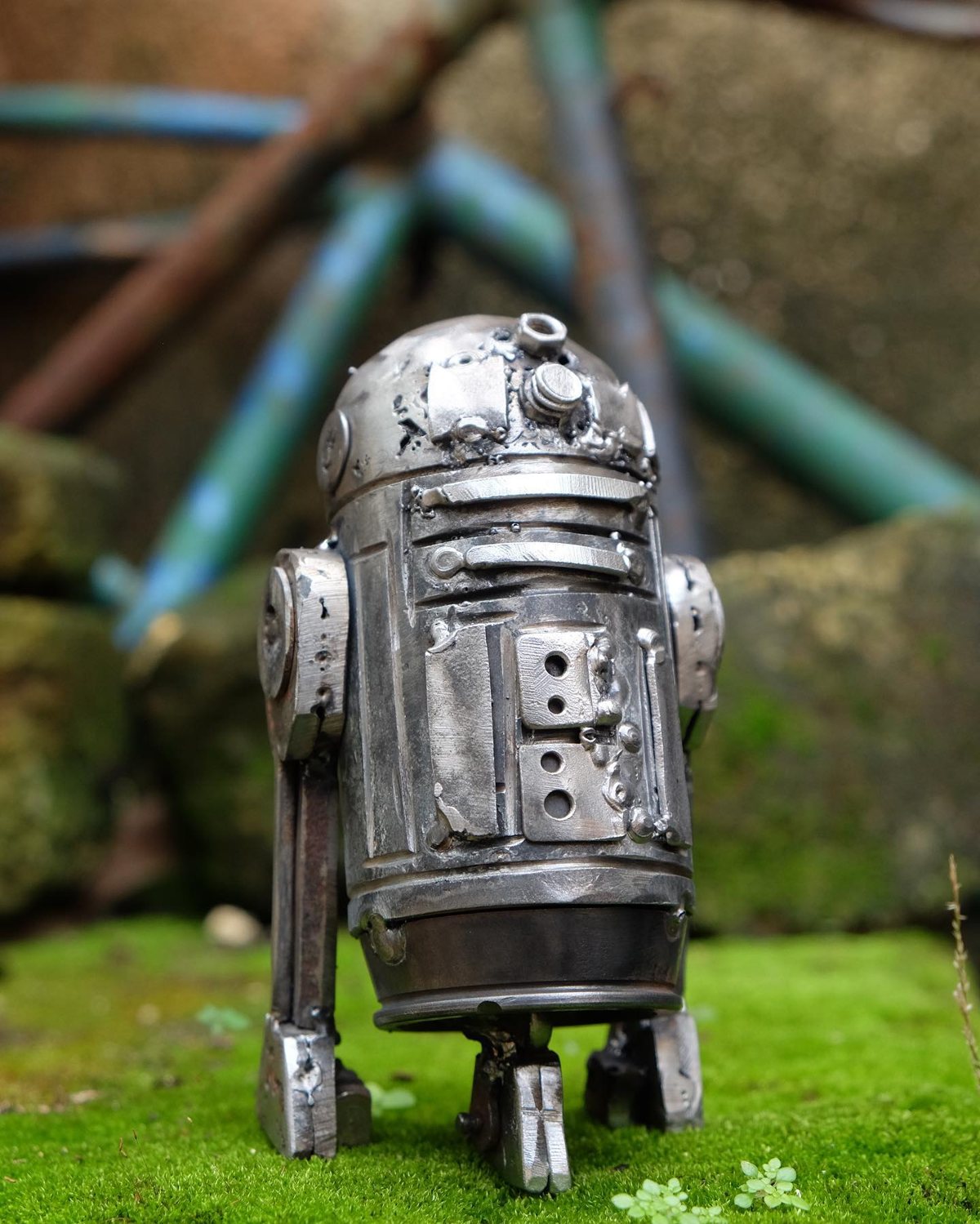 Escultura de Pedro Cuellar: droide de metal plateado con tres patas