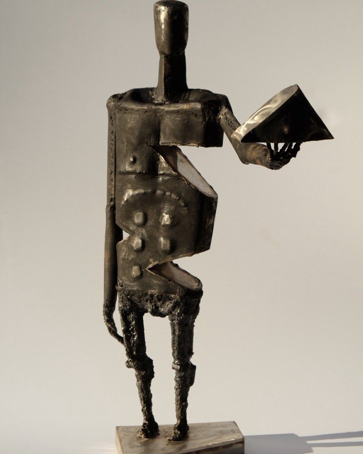 Escultura de Pedro Cuellar: figura de metal que sostiene un libro abierto