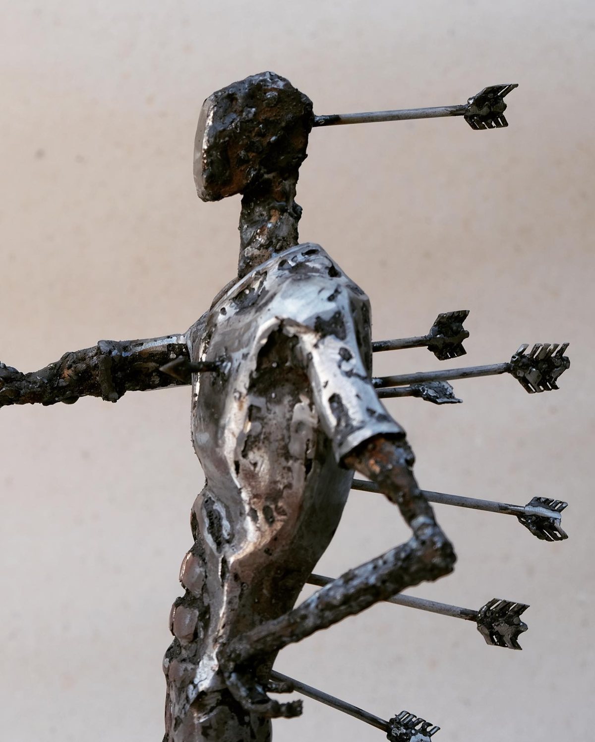 Escultura de Pedro Cuellar: figura de metal atravesada por flechas