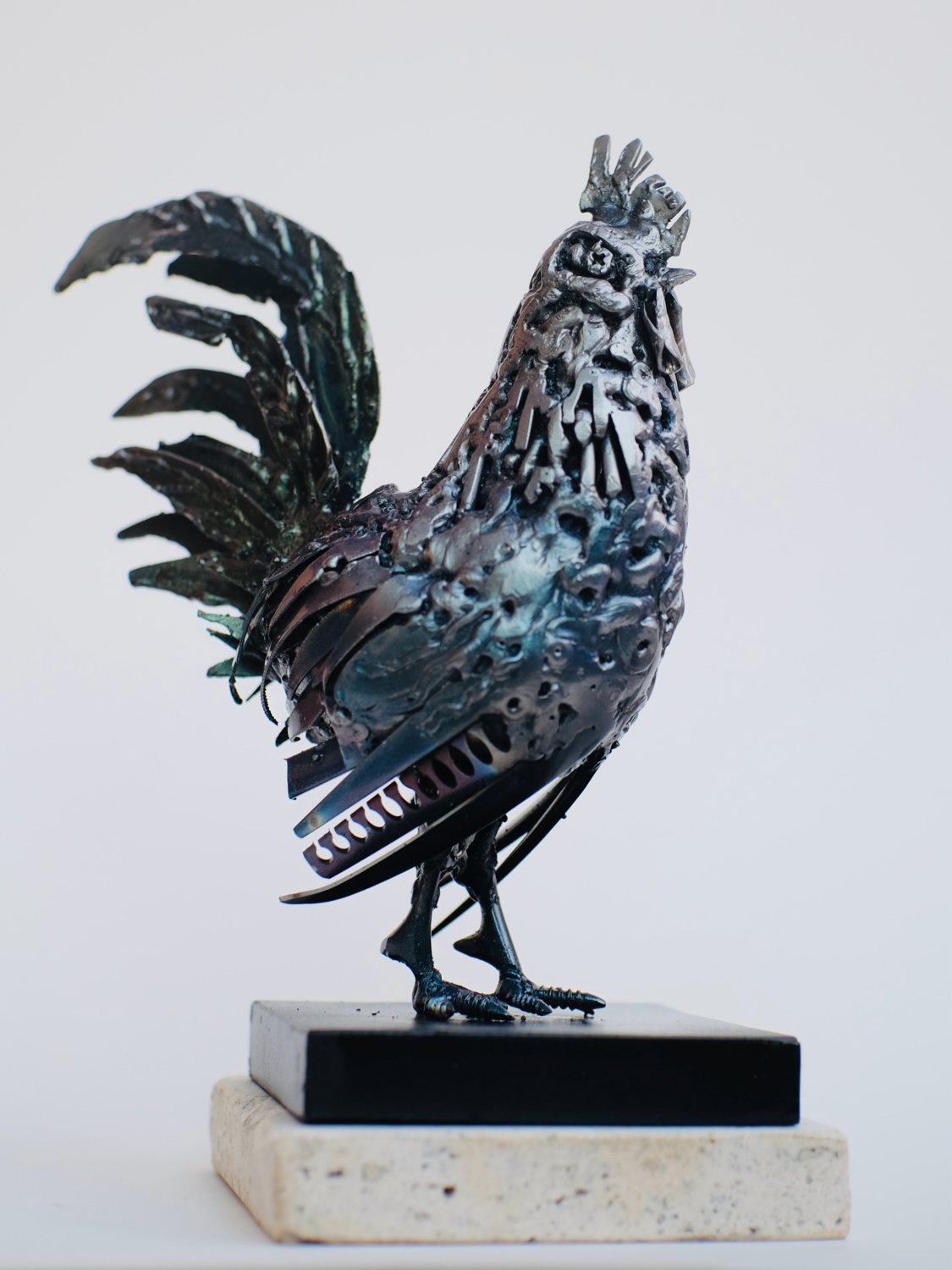 Escultura de Pedro Cuellar: gallo de metal con las plumas de la cola levantadas