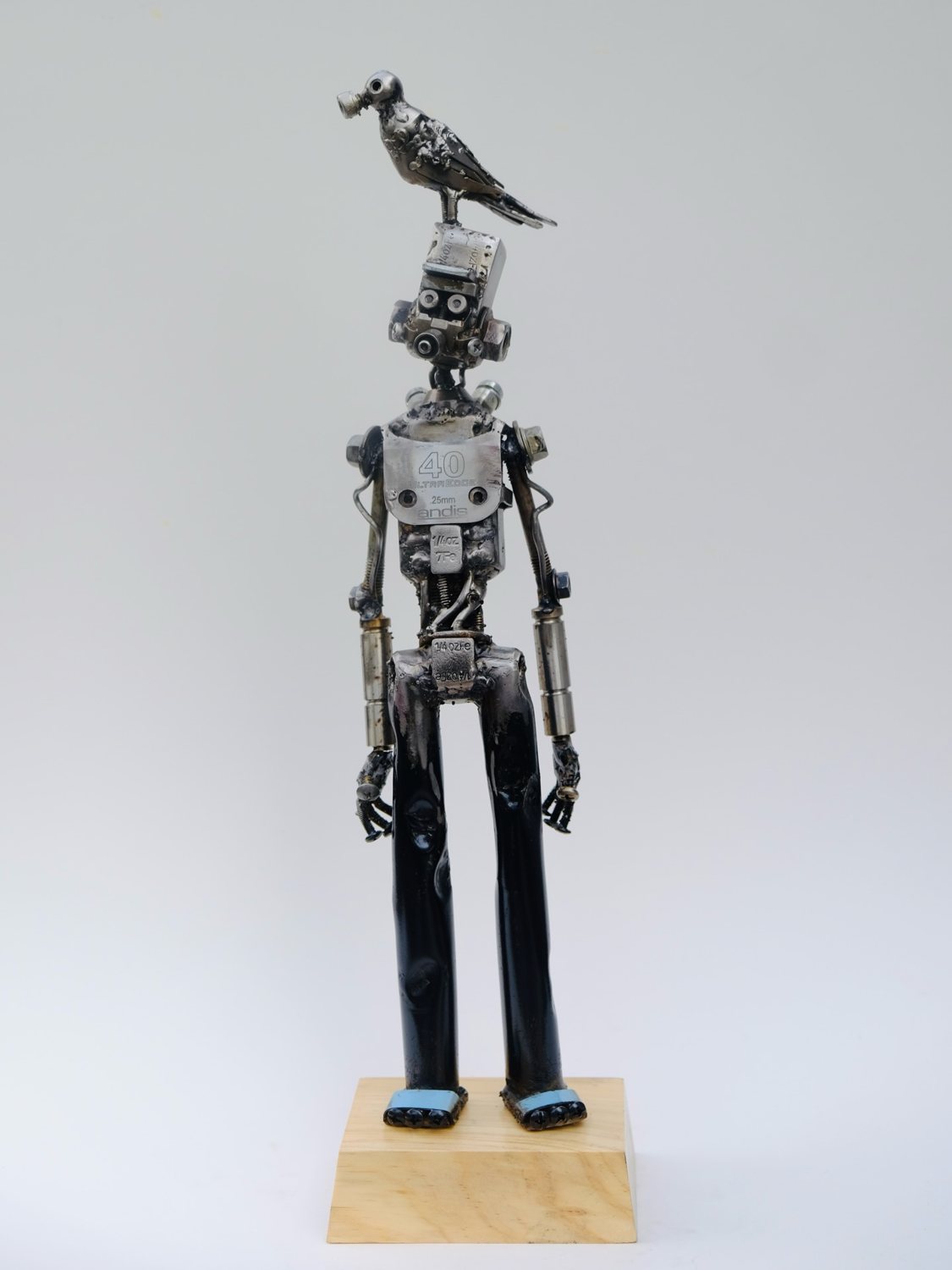 Escultura de Pedro Cuellar: figura de metal con un cuervo sobre la cabeza
