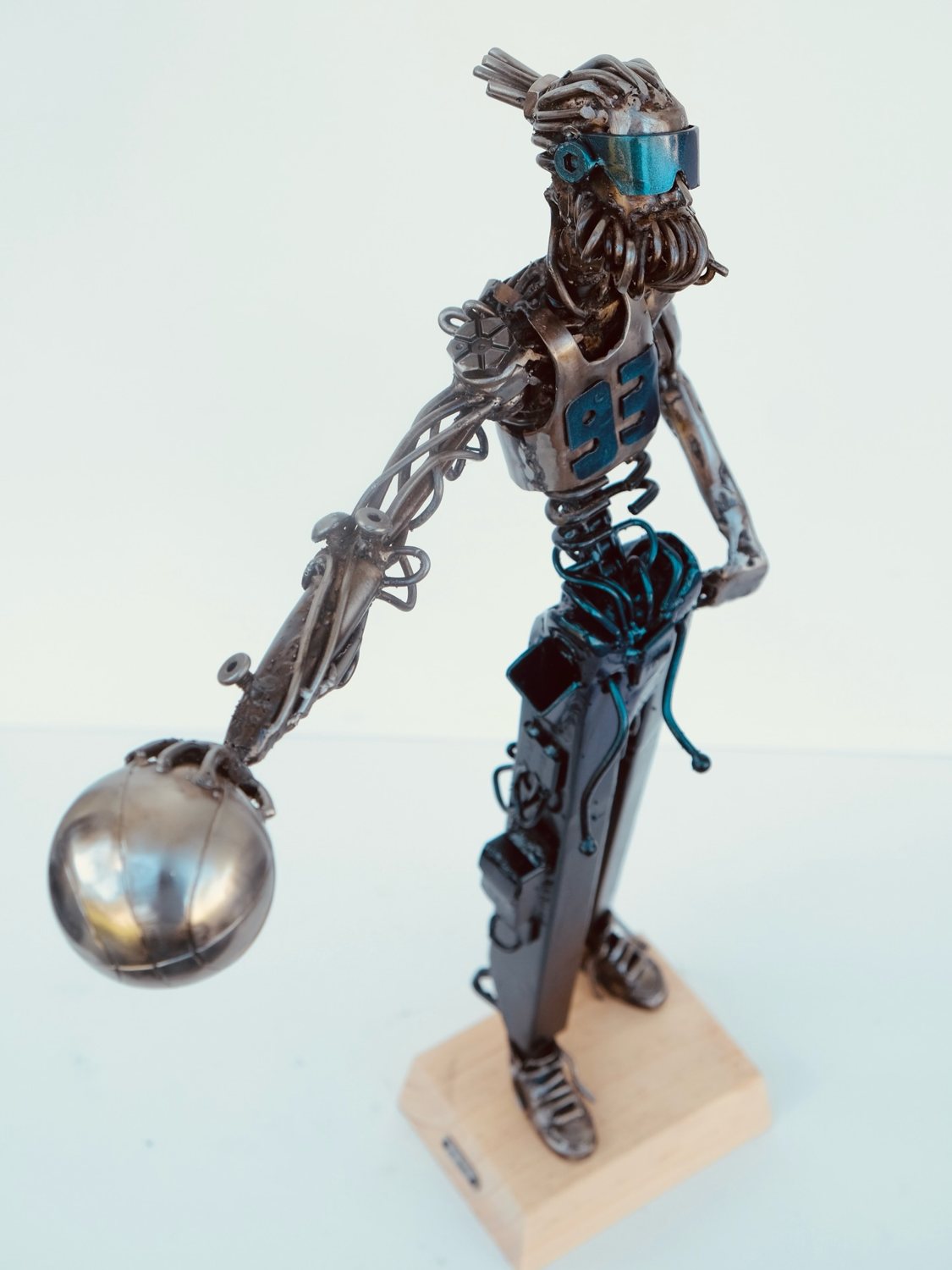 Escultura de Pedro Cuellar: figura de metal que lanza una bola plateada