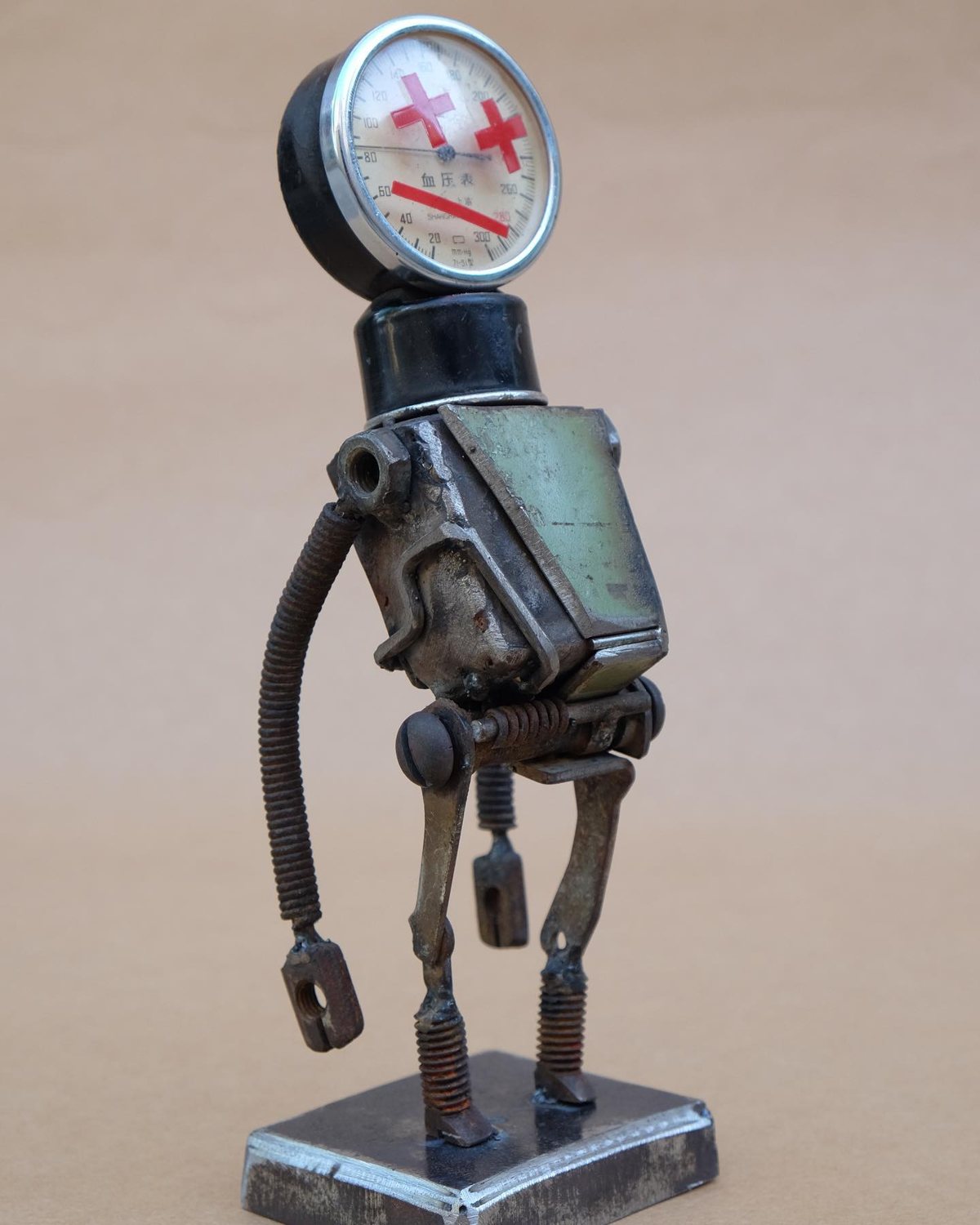 Escultura de Pedro Cuellar: robot de metal con un manómetro como cabeza